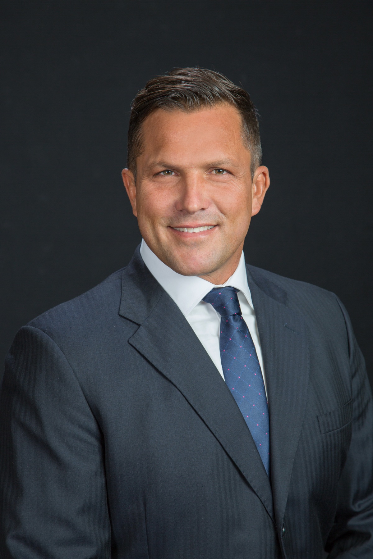 Erik Gladish, Realtor with eXp Realty of California, in a navy suit